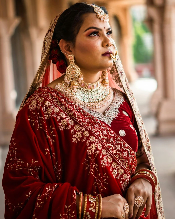 a woman in a red and gold bridal outfit